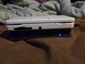 On the new model, the game slot is moved to the bottom to make room for the new buttons.